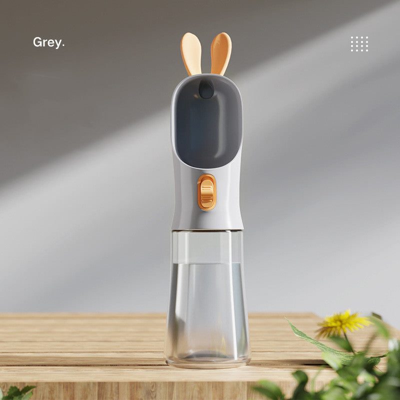 Gray portable pet travel water bottle with dual-function lid and silicone grip.