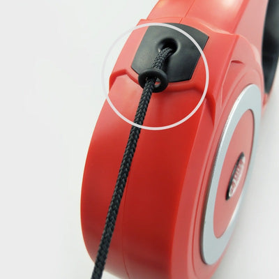 Red retractable pull strap for dogs with ABS material, close-up view.