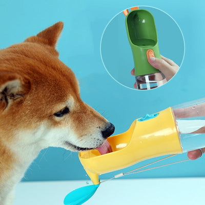 Portable pet travel water bottle in use, dispensing water to a dog.