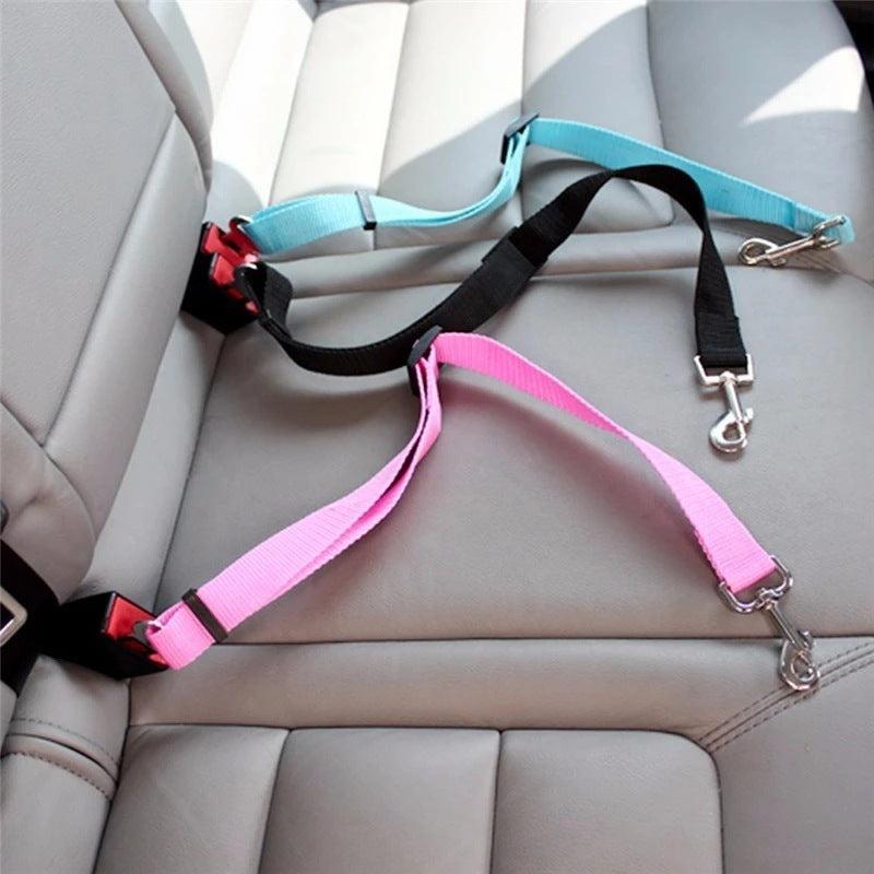 Pet retractable car seat belt in pink and blue on car seat, ensuring pet safety during travel.