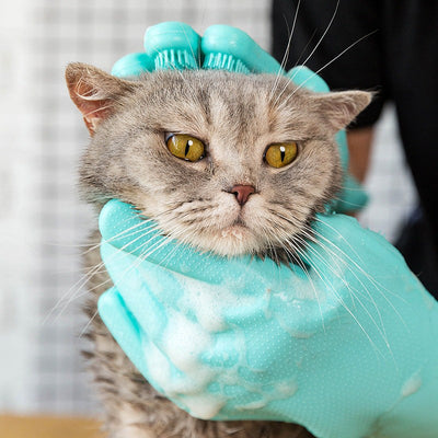 Green pet grooming gloves bathing a gray cat, highlighting soft silicone material for comfortable massage.