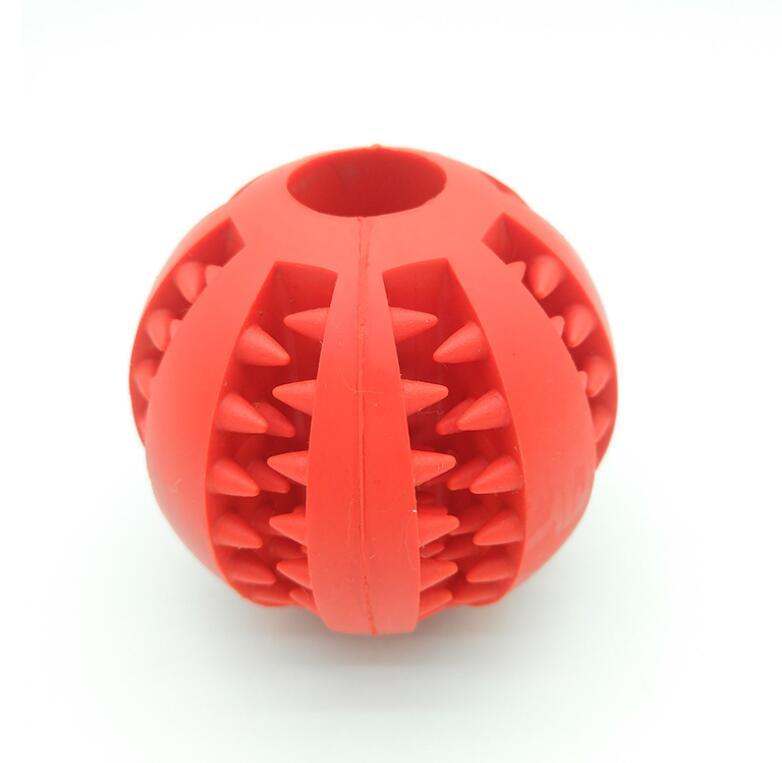 Red rubber feeder dog ball toy with spikes for pet play and tooth cleaning.