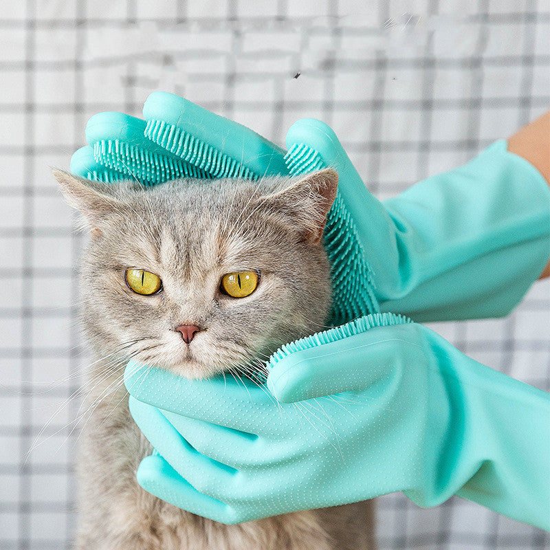 Pet grooming gloves massaging a grey cat.